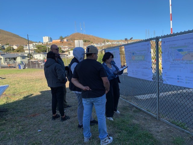 Group of people looking at posters on fence