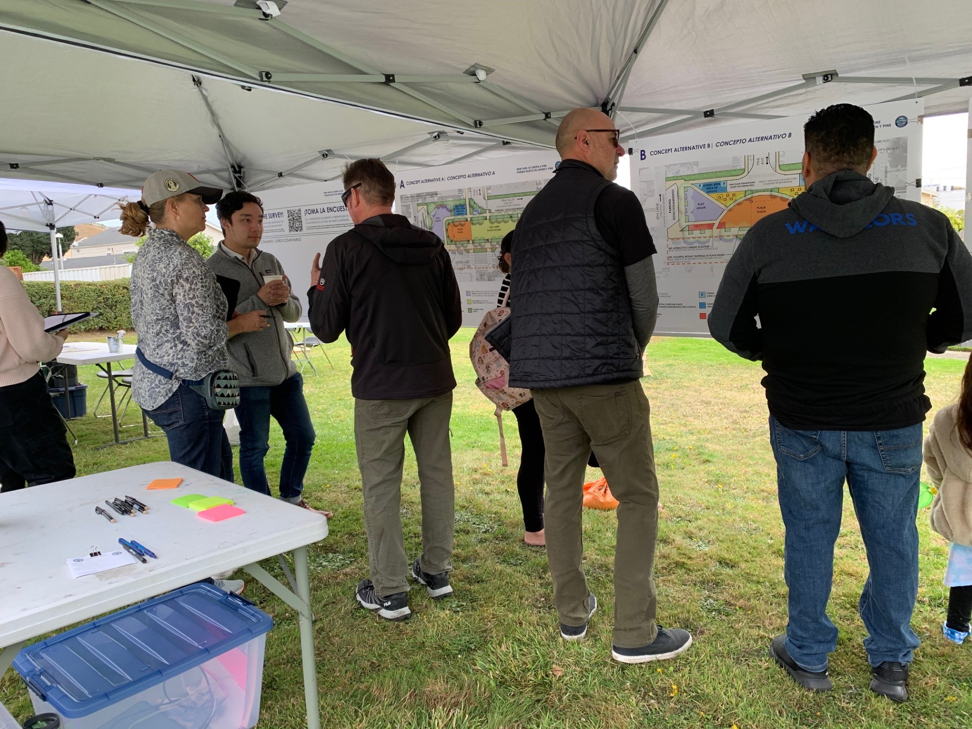 People in front of posterboards under tent